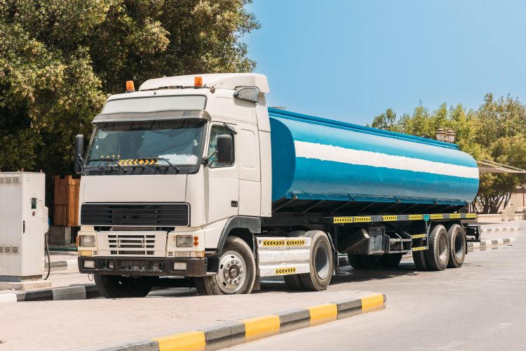 Water tank trailer unit, prime mover, refuel at gas and oil station in sunny summer day. Water tank
